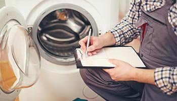 image of a worker preparing to repair a washing machine covered by a home warranty plan.
