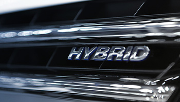 the word Hybrid written on a car's grill.