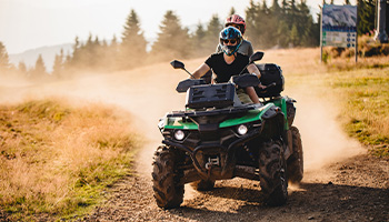 two people on an ATV going down a trail