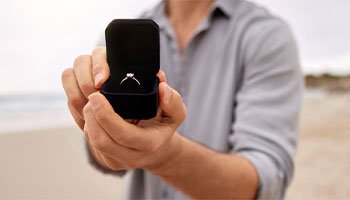 a person holding an engagement ring, which is a valuable that could be protected with jewelry insurance